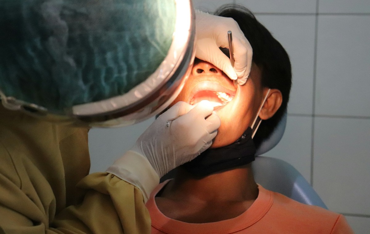 a man getting his teeth checked by a dentist